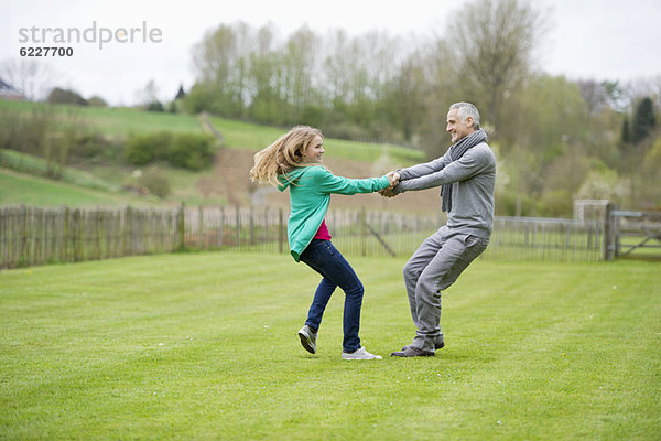 Mann spielt mit seiner Tochter auf einem Feld
