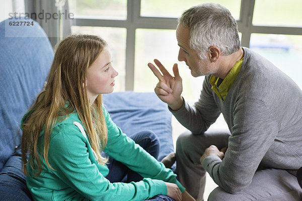 Mann im Gespräch mit seiner Tochter zu Hause