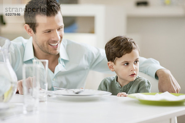 Mann mit seinem Sohn am Esstisch sitzend