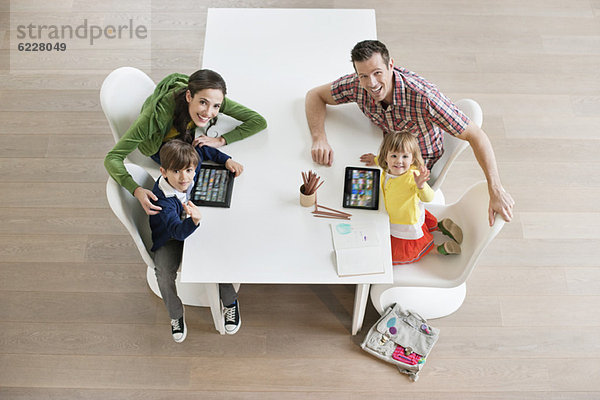 Hochwinkelansicht des Paares mit seinen Kindern am Arbeitstisch
