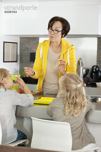 Ältere Frau mit ihren Enkelinnen in der Küche