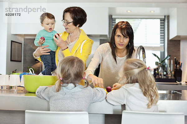 Mädchen mit ihrer Mutter und Großmutter in der Küche