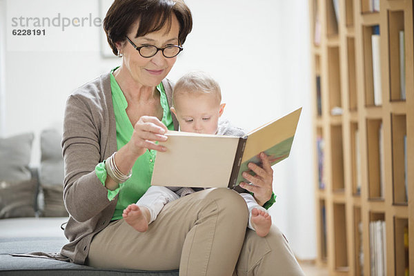 Frau mit ihrer Enkelin beim Lesen eines Bilderbuches