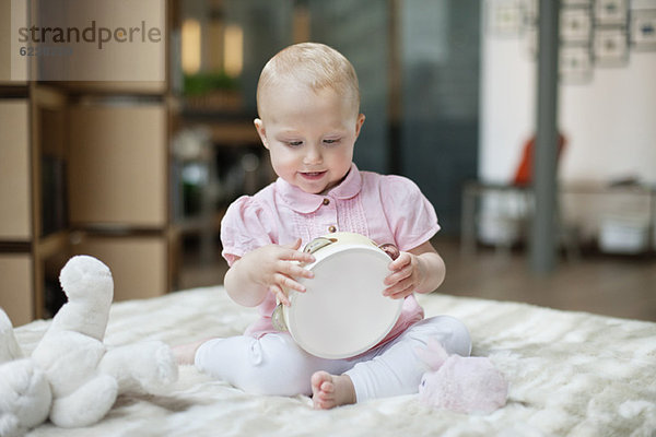Kleines Mädchen spielt mit einem Tamburin