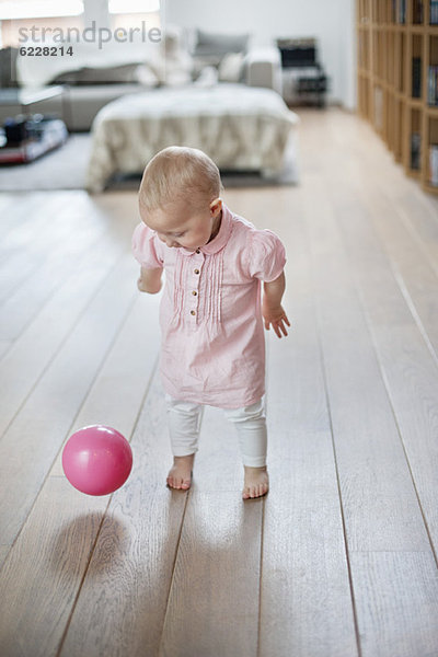 Kleines Mädchen spielt mit einem Ball