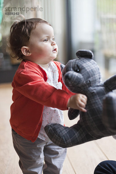 Kleines Mädchen mit Teddybär im Arm