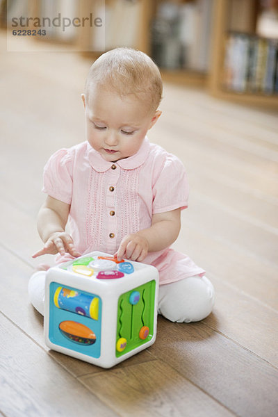 Kleines Mädchen spielt mit einem musikalischen Blockspielzeug