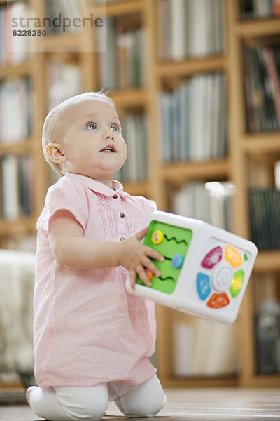 Kleines Mädchen spielt mit einem musikalischen Blockspielzeug
