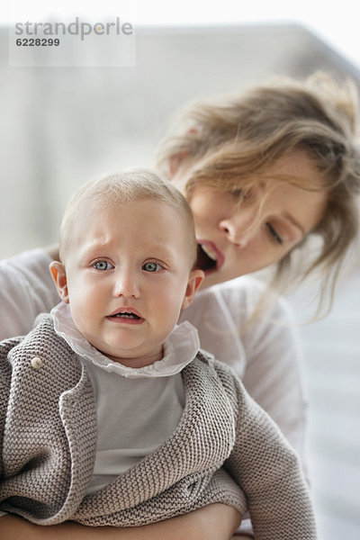 Frau tröstet ihr weinendes Baby