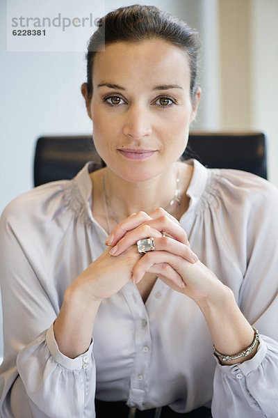 Porträt einer Geschäftsfrau mit den Händen in einem Büro