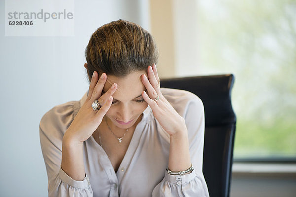 Nahaufnahme einer Geschäftsfrau mit Kopfschmerzen im Büro