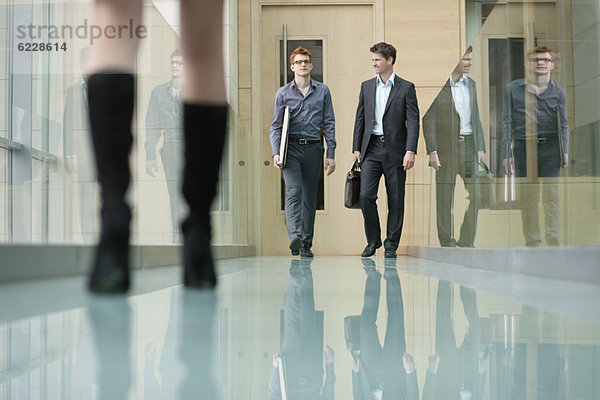 Geschäftsleute  die in einem Korridor spazieren gehen