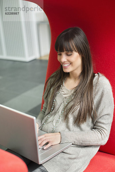 Geschäftsfrau mit Laptop und Lächeln im Büro