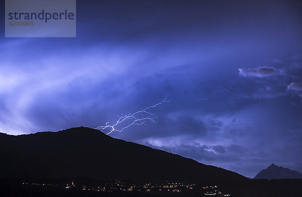 Bedrohliche Wolkenstimmung und Blitze aus einer Gewitterzelle über dem Patscherkofel bei Innsbruck  Nachtaufnahme  Tirol  Österreich  Europa Österreich