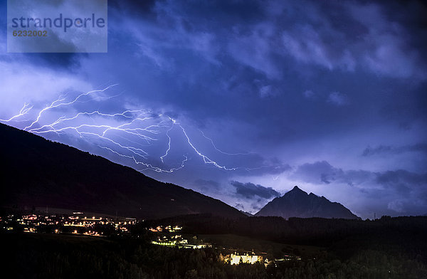 Bedrohliche Wolkenstimmung und Blitze aus einer Gewitterzelle über dem Stubaital bei Innsbruck  hinten Serles und Orte Aldrans und Lans  Nachtaufnahme  Innsbruck  Tirol  Österreich  Europa