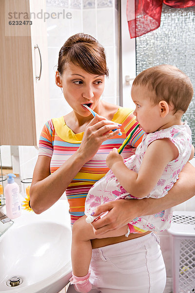 Mutter und kleine Tochter putzen Zähne