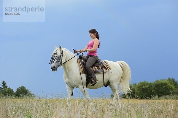 Teenagerin reitet auf einem Pferd