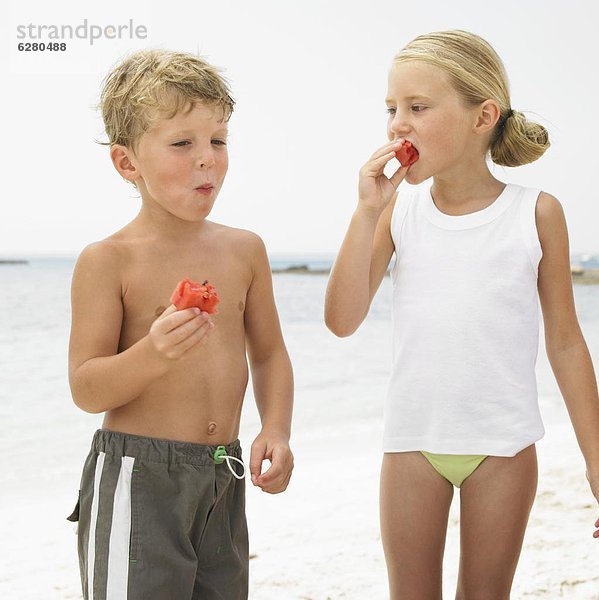 Strand  Junge - Person  Wassermelone  essen  essend  isst  Mädchen