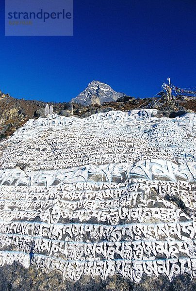 Felsbrocken  streichen  streicht  streichend  anstreichen  anstreichend  Schriftzeichen  fünfstöckig  Buddhismus  Namche Bazaar  Nepal