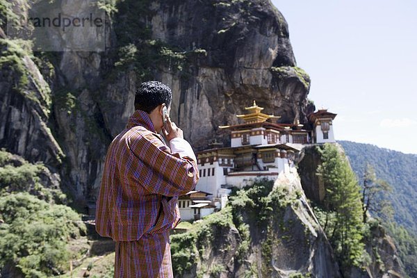 Bhutanischen Mann mit Handy  Kloster Taktsang Goemba (Tiger Nest)  Paro  Bhutan  Asien