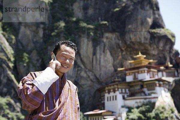 Bhutanischen Mann mit Handy  Kloster Taktsang Goemba (Tiger Nest)  Paro  Bhutan  Asien