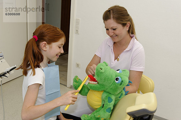 Mädchen beim Zahnarzt  Anleitung zur Zahnpflege an einem Modell  Zahnhygiene  Zahnvorsorge  Zahnarztbesuch