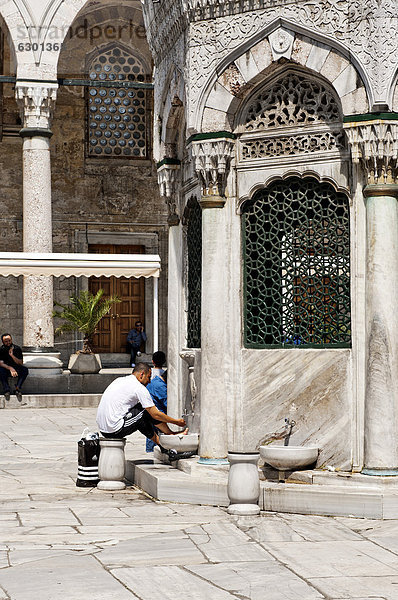 Mann wäscht sich die Füße im Waschhaus im Hof der Neuen Moschee  Yeni Cami  Istanbul  Türkei