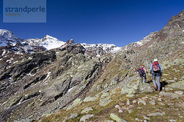 Wanderer beim Aufstieg zur hinteren Eggenspitz im Ultental oberhalb des Grünsees  hinten die Weißbrunnspitz  Südtirol  Italien  Europa