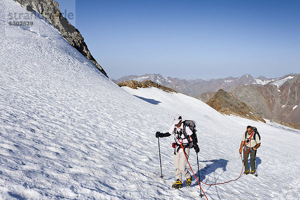 Wanderer beim Aufstieg zum Similaun auf dem Niederjochferner im Schnalstal oberhalb des Fernagt Stausees  hinten der Große Kahndl  Südtirol  Italien  Europa
