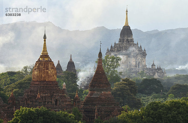 Aufsteigender Rauch zwischen Tempeln und Pagoden  Bagan  Myanmar  Burma  Birma  Südostasien  Asien