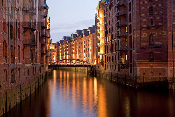 Beleuchtete Lagerhäuser und Kanal in der Speicherstadt  Freie und Hansestadt Hamburg  Deutschland  Europa