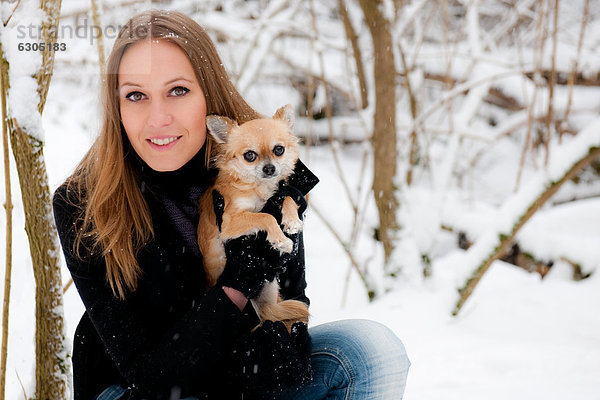Junge Frau mit einem Hund im Schnee  Portrait