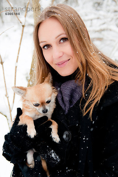 Junge Frau mit einem Hund im Schnee  Portrait