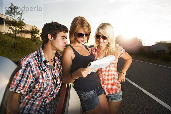 Drei Freunde gucken auf eine Straßenkarte