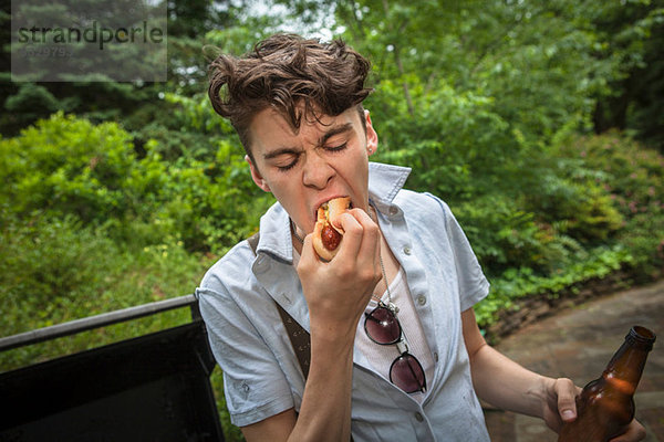 Junger Mann beim Essen eines Hotdogs