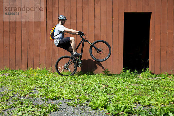 Mountainbikefahren auf einem Rad außerhalb der Scheune