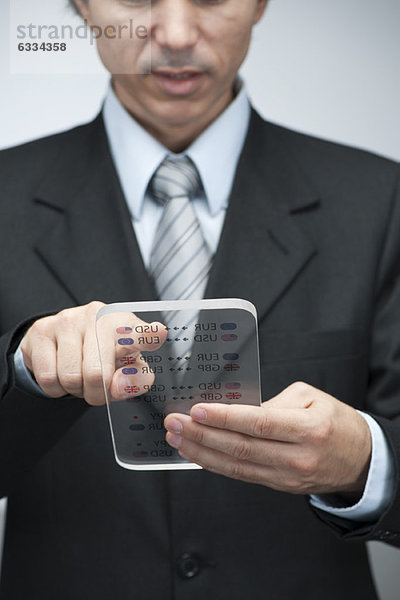 Geschäftsmann liest Geschäftsdaten auf einem fortschrittlichen digitalen Tablett  beschnitten