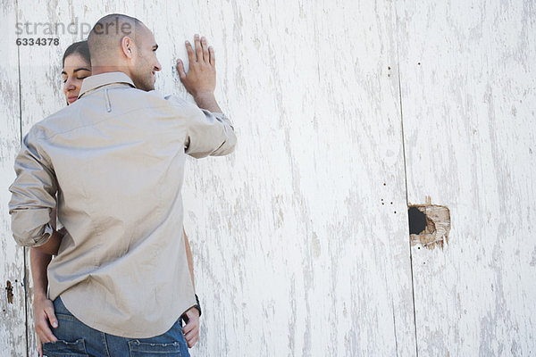 Paar gegen die Wand lehnend  außermittig