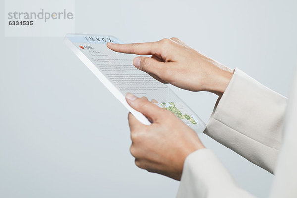 Frau überprüft E-Mail mit futuristischem digitalem Tablett  beschnitten