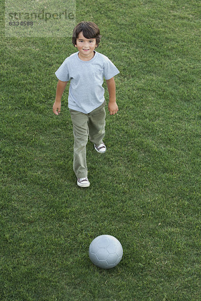 Junge spielt mit Ball im Freien