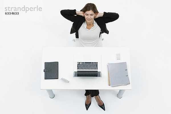 Geschäftsfrau entspannt am Schreibtisch mit geschlossenen Augen