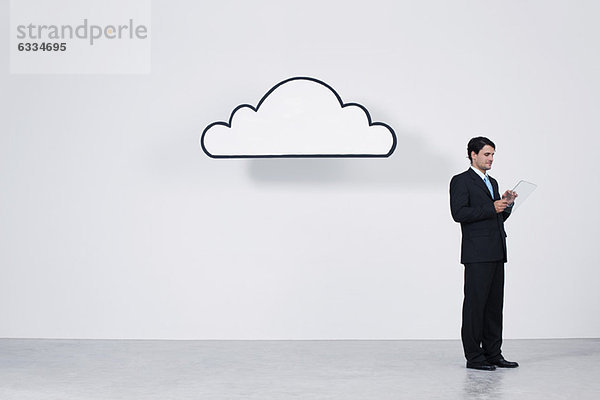 Geschäftsmann mit digitalem Tablett unter der Wolke  das Cloud Computing darstellt