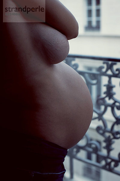 Halbnackte Schwangere  Mittelteil  Seitenansicht