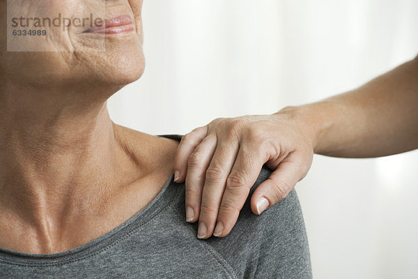 Beruhigende Hand auf der Schulter der Seniorin  abgeschnitten