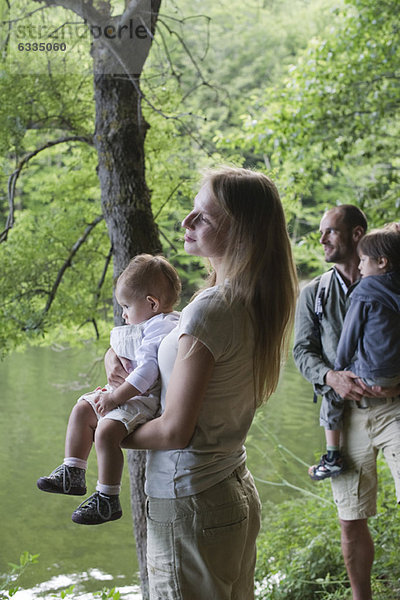 Familie im Wald mit Blick auf den Fluss  Konzentration auf die Mutter mit dem kleinen Mädchen