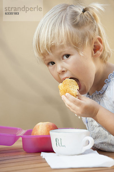 Kleines Mädchen isst einen Snack