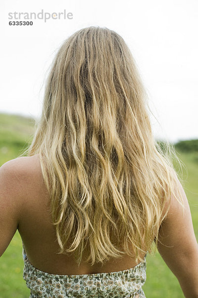 Junge Frau mit langen blonden Haaren  Rückansicht