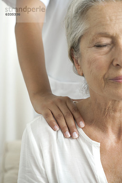 Ältere Frau bekommt eine Schultermassage  abgeschnitten