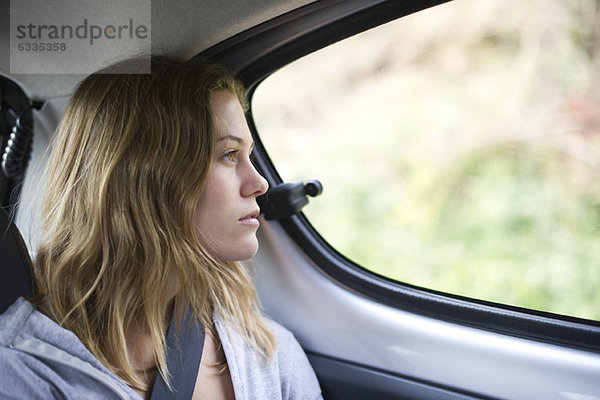 Junge Frau im Auto mit Blick aus dem Fenster