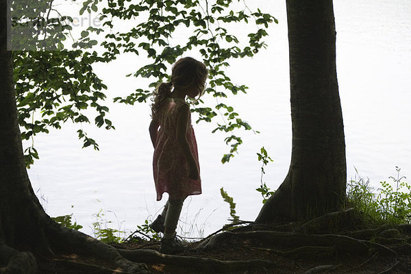Silhouette des Mädchens am See stehend